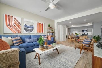 Riverside apartment for rent - A living room with a blue couch and a coffee table.