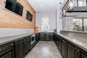 Oxnard apartment for rent - A modern kitchen with black cabinets and a wooden wall.