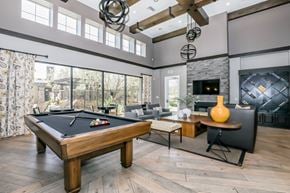 Oxnard apartment for rent - A pool table is in the middle of a room with a fireplace and a TV.