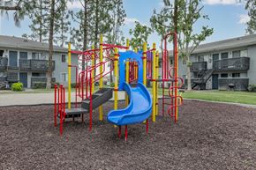 San Bernardino apartment for rent - A playground with a blue slide and red and yellow climbing structures.