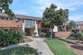 Oceanside apartment for rent - A sunny day at a residential complex with a clear blue sky.