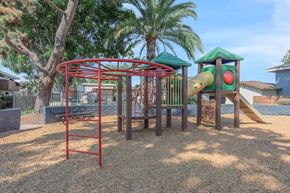 Oceanside apartment for rent - A playground with a red swing set and a green slide.