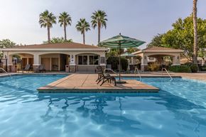 Clovis townhouse for rent - A pool with a wooden deck and a green umbrella.