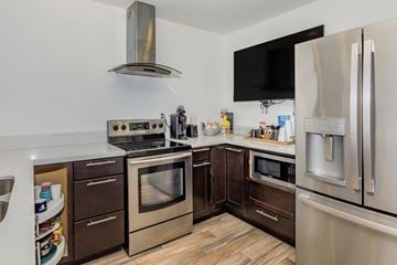 Redlands apartment for rent - A modern kitchen with stainless steel appliances and wooden flooring.