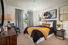 Simi Valley apartment for rent - A bedroom with a bed covered in a black and yellow blanket.