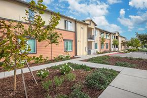 Santa Maria apartment for rent - A row of modern apartment buildings with a sidewalk and landscaping in front.
