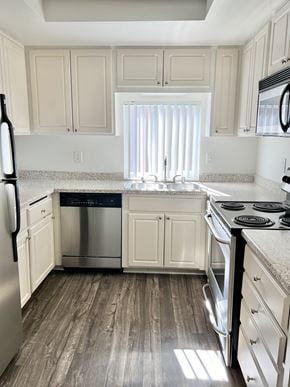 Riverside apartment for rent - A kitchen with white cabinets and a stainless steel dishwasher.