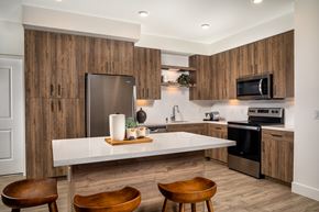 Simi Valley apartment for rent - A modern kitchen with wooden cabinets and a white island.