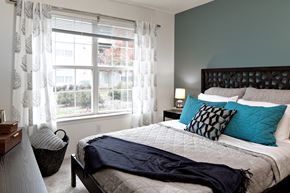 Lawrenceville apartment for rent - A bedroom with a large bed and a window with curtains.