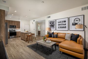 Simi Valley apartment for rent - A modern living room with a brown leather couch and a coffee table.