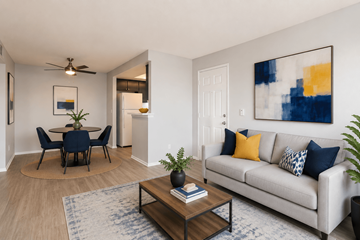 Lancaster townhouse for rent - A living room with a white couch, a dining table with chairs, a ceiling fan, and a painting on the wall.