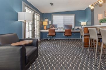 Visalia apartment for rent - A living room with a grey carpet and a black leather sofa.