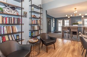 Visalia apartment for rent - A living room with a bookshelf, a chair, and a table.