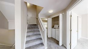 Manchester apartment for rent - A staircase with a carpeted runner leads to a bedroom with a dresser and a wardrobe.
