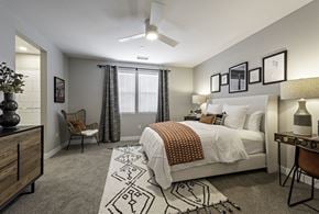 Clovis townhouse for rent - A bedroom with a bed, chair, and decorative items.