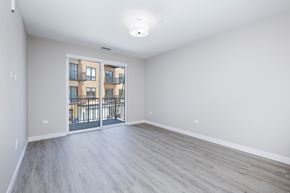Lombard apartment for rent - A spacious room with a view of a building through a glass door.