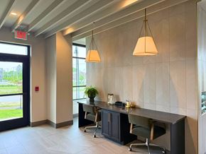 South Bend apartment for rent - A modern office space with a desk, chairs, and a hanging light fixture.