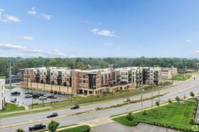 South Bend apartment for rent - A view of a road with cars and apartment buildings.