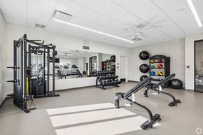 Elkhart apartment for rent - A spacious gym with a variety of equipment including a squat rack, a bench press, and a rowing machine.