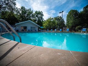 Elkhart apartment for rent - a swimming pool with chairs and a house in the background