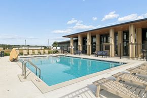 Elkhart apartment for rent - A pool with sun loungers and a building in the background.