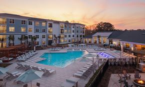 Johns Island apartment for rent - A large outdoor swimming pool surrounded by lounge chairs and umbrellas.
