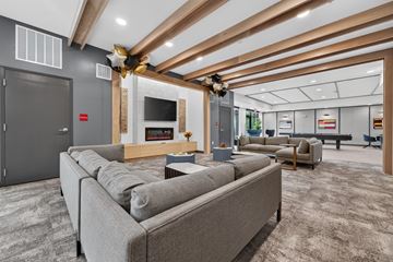 Kokomo apartment for rent - A modern living room with a grey sofa and a wooden ceiling.