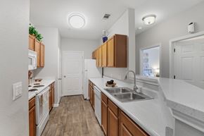 Pensacola apartment for rent - A kitchen with wooden cabinets and white countertops.