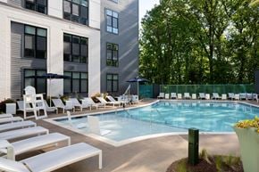 Alexandria apartment for rent - a swimming pool with chairs and umbrellas in front of a building
