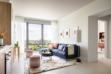 Chicago apartment for rent - A living room with a blue couch and a large window overlooking the city.