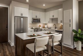 Dallas apartment for rent - A kitchen with white cabinets and a wooden floor.