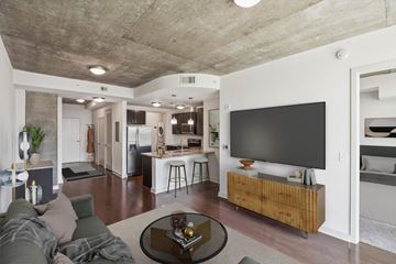Atlanta apartment for rent - A modern living room with a grey couch and a black television.