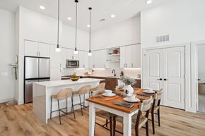Lewisville apartment for rent - A modern kitchen with a dining table set for four.