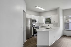 Orlando apartment for rent - A kitchen with white cabinets and a stainless steel refrigerator.