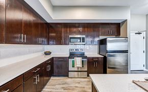 Kansas City apartment for rent - A kitchen with dark wood cabinets and stainless steel appliances.