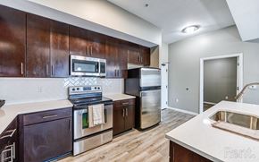 Kansas City apartment for rent - A kitchen with dark wood cabinets and stainless steel appliances.