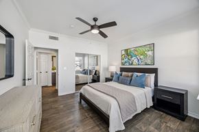 Plano apartment for rent - A bedroom with a large bed and a ceiling fan.