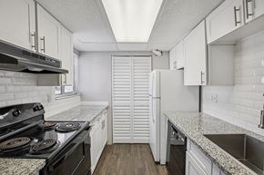 Tampa apartment for rent - A kitchen with a black stove top oven and white cabinets.
