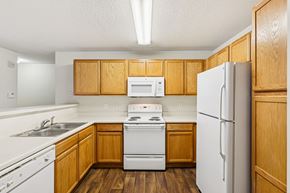 Salisbury apartment for rent - A kitchen with wooden cabinets and white appliances.