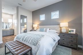 Justin apartment for rent - A bedroom with a large bed, a bench, and a dresser.