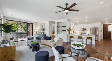 Dallas apartment for rent - A modern living room with a ceiling fan and a dining table with chairs.