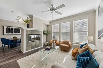 Dallas apartment for rent - A living room with a glass coffee table and a grey sofa.