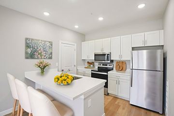 Lawrence apartment for rent - A kitchen with a white table and chairs and a painting on the wall.