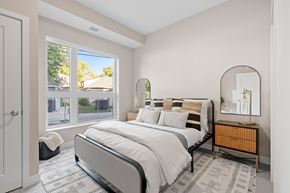 Minneapolis apartment for rent - A bedroom with a large bed and a view of the street outside the window.
