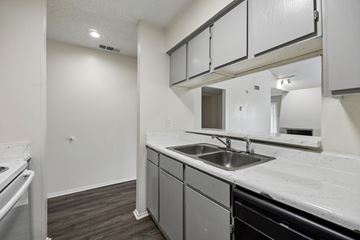 Dallas apartment for rent - A kitchen with a sink and a stove top oven.