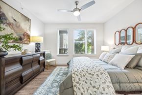 Plano apartment for rent - A bedroom with a large bed and a ceiling fan.