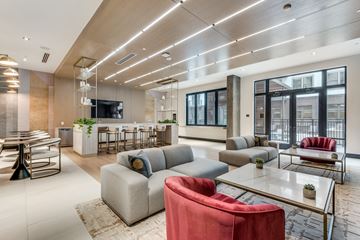Dallas apartment for rent - A modern living room with a red chair and a glass table.