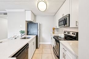 Wellington apartment for rent - A kitchen with white cabinets and black appliances.