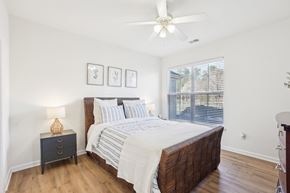 Knightdale apartment for rent - A bedroom with a large bed and a ceiling fan.