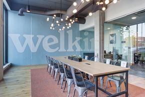 Des Plaines apartment for rent - A conference room with a long table and chairs with a sign that says Welki.